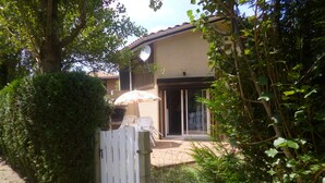 Una casa con patio, una reja blanca y una antena parabólica.
