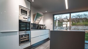 Una cocina moderna con electrodomésticos integrados, un amplio ventanal y vistas al exterior.