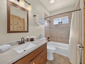 Une salle de bain avec un meuble-lavabo à deux vasques, des toilettes et une baignoire.
