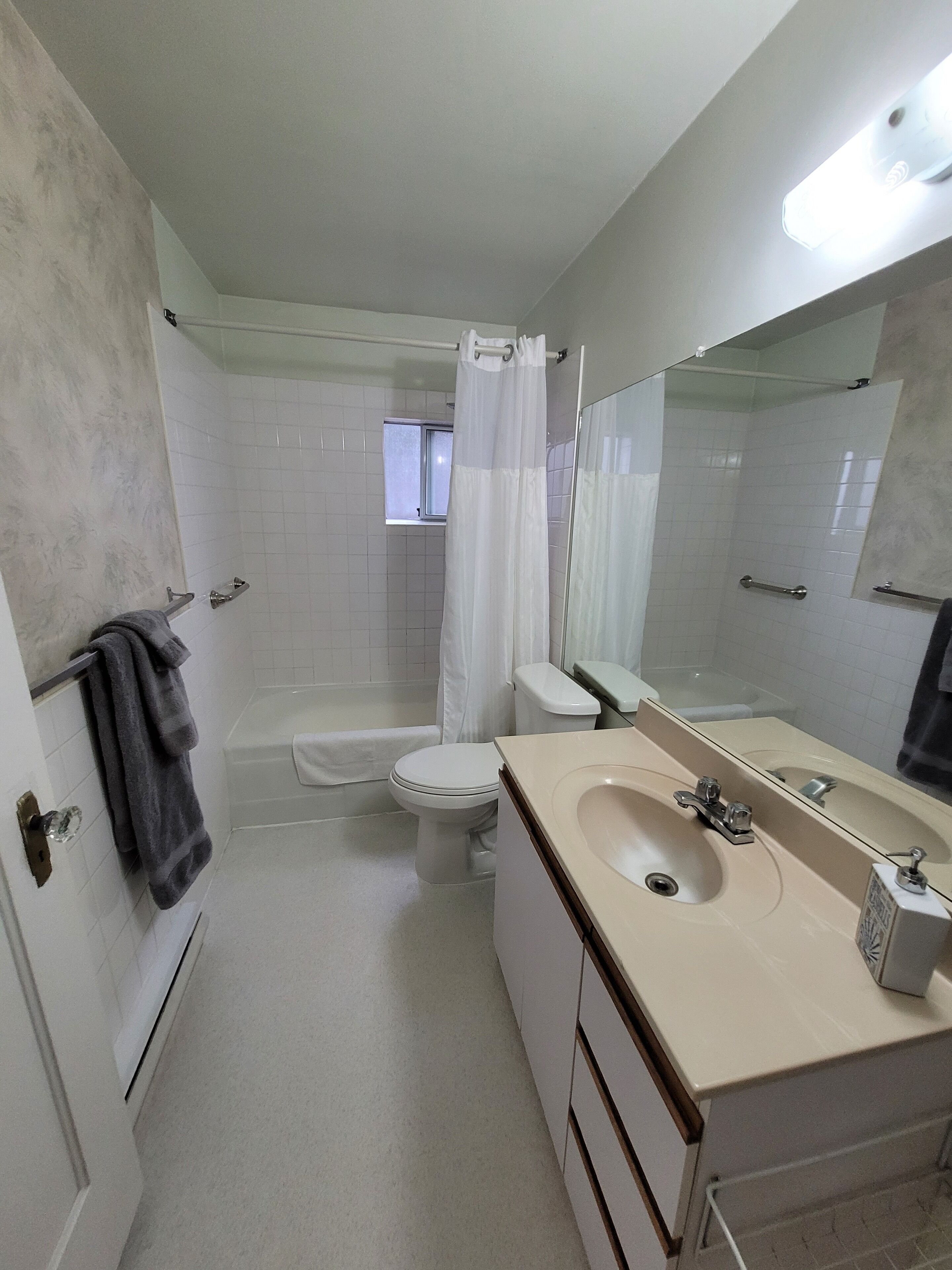 Un baño con bañera, inodoro y lavamanos.