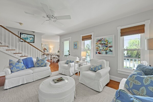 A spacious living room with white furniture, a ceiling fan, and large windows with blinds. - Family Home w/ Private Pool & A two min. walk to the Beach. Lots of extras (Isle of Palms)