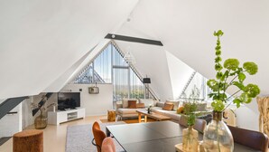 Un loft moderno con comedor, sala de estar y un amplio ventanal que proporciona luz natural.