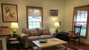 A cozy living room with a sofa, two lamps, a coffee table, and a chair.