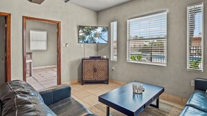 A living room with a sofa, a coffee table, a TV, and a cabinet. - Shadow Palm Villa 3 Private Resort Villa (Port Aransas)