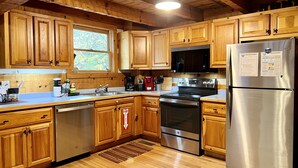 A kitchen with wooden cabinets, stainless steel appliances, and a window.