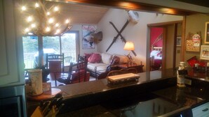 A cozy living room with a fireplace, a mounted deer head, and a sign for the "Otsey Club."