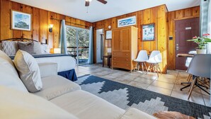 A room with a bed, a sofa, a dining area with chairs, a wooden wardrobe, and a ceiling fan. - 1 Min from Sequoia National Park Cabin for 2 with additional sleeper sofa (Three Rivers)