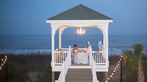 Gazebo con rivestimento bianco e tetto, affacciato sull'oceano.