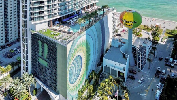 A high-rise hotel with a rooftop pool and a large mural. - 2 Bedroom Ocean View Escape with Premium Amenities (Hollywood)