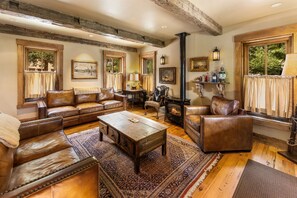 Ein gemütliches Wohnzimmer mit Ledersofas, einem Couchtisch und einem Kamin.