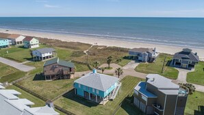 A coastal residential area with houses, a beach, and a clear sky. - Beautiful view of the beach, 3 bedroom-3 full bath, WiFi, cable, big deck (Galveston)