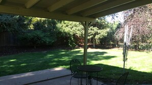 A covered patio with a concrete floor, two metal chairs, and a table. - PETS welcome! CSU/mid-town Home!  (Fort Collins)
