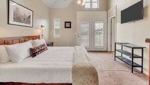 A bedroom with a bed, a ceiling fan, a TV, and a door leading to a balcony. - Ski-In/Ski-Out, Hot Tub, Walk to Main Street (Park City)