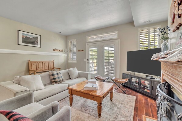 A living room with a sofa, coffee table, TV stand, and a fireplace. - Ski-In/Ski-Out, Hot Tub, Walk to Main Street (Park City)