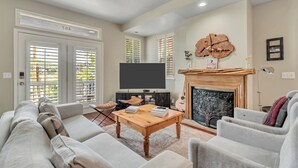 A living room with a fireplace, a television, and a sofa. - Ski-In/Ski-Out, Hot Tub, Walk to Main Street (Park City)