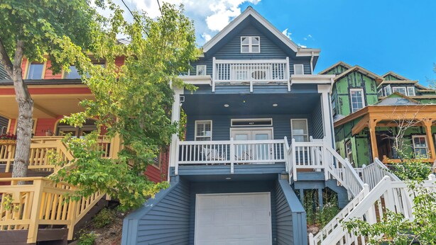 A two-story house with a front garage, wooden stairs, and a balcony. - Ski-In/Ski-Out, Hot Tub, Walk to Main Street (Park City)