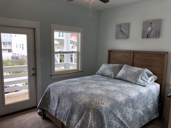 Un dormitorio con una cama, una ventana y dos cuadros colgados en la pared.