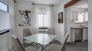 Een moderne keuken met witte kasten, een roestvrijstalen spoelbak en een inbouwvaatwasser.