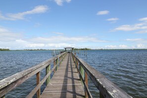 A wooden pier extending into a body of water with a clear sky above.