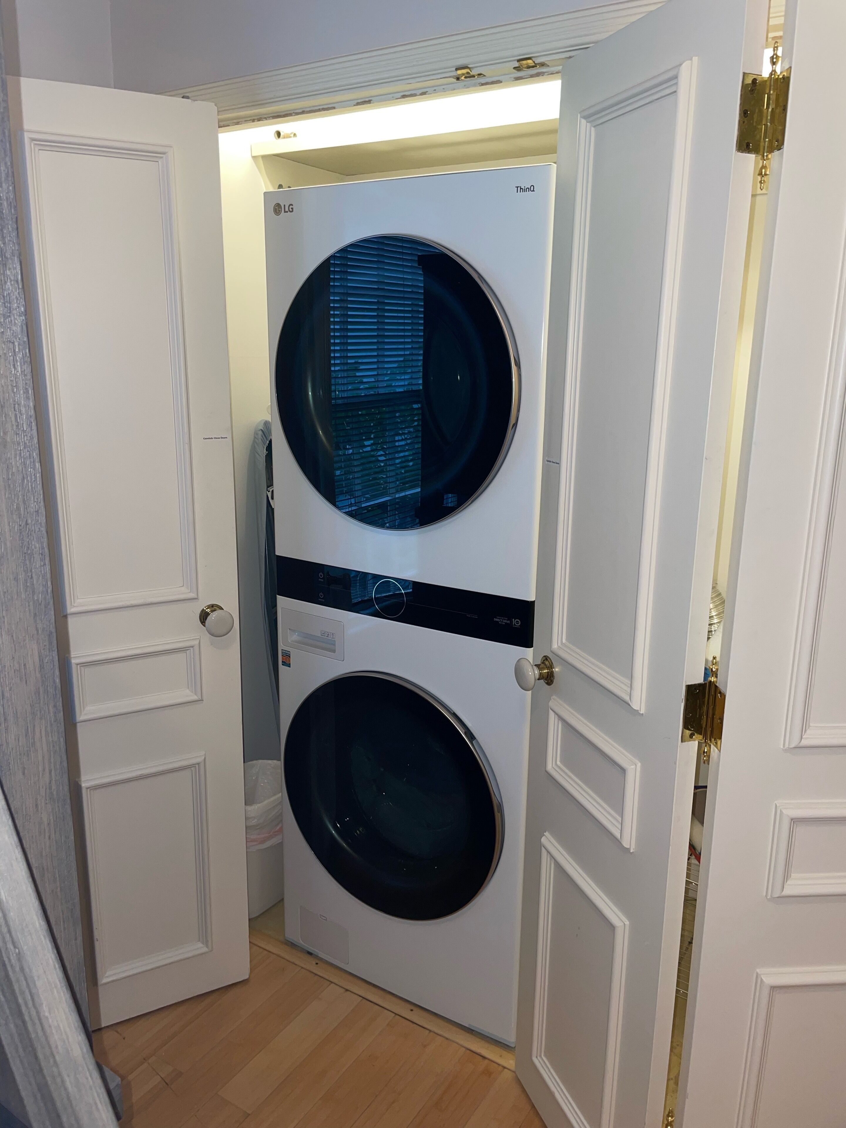 A compact laundry room with two stacked front-loading washing machines.
