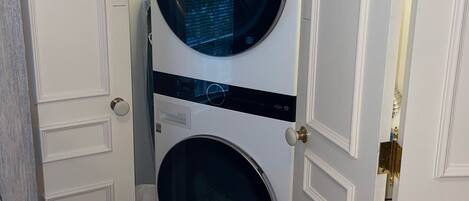 A compact laundry room with two stacked front-loading washing machines.