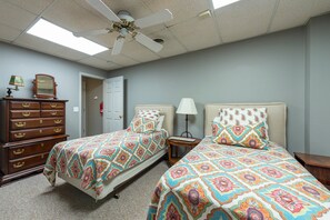 A hotel room with two beds, a dresser, a ceiling fan, and a door. - Mountain View | 4 BD Pet-Friendly Montreat Home | Game Room (Montreat)