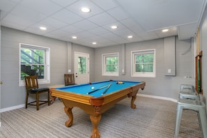 A pool table in a room with a carpeted floor, white walls, and windows. - Mountain View | 4 BD Pet-Friendly Montreat Home | Game Room (Montreat)