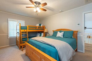 A bedroom with a bunk bed, a ceiling fan, a window with blinds, and a door. - Mountain View | 4 BD Pet-Friendly Montreat Home | Game Room (Montreat)