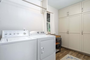 A laundry area with two washing machines, a drying rack, and a window with curtains. - Mountain View | 4 BD Pet-Friendly Montreat Home | Game Room (Montreat)