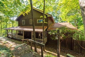 A wooden cabin with a porch, surrounded by trees. - Mountain View | 4 BD Pet-Friendly Montreat Home | Game Room (Montreat)