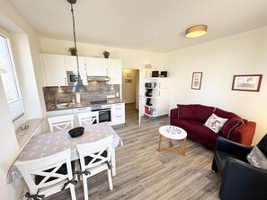 Um espaço compacto com cozinha compacta, área de refeições e espaço para sentar.