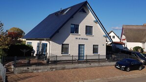 A white building with a blue roof and a sign that reads 'BYP AN ZIRINBAGH.' - Hus at Zickenbarg - Apartment Hus at Zickenbarg (Zempin)