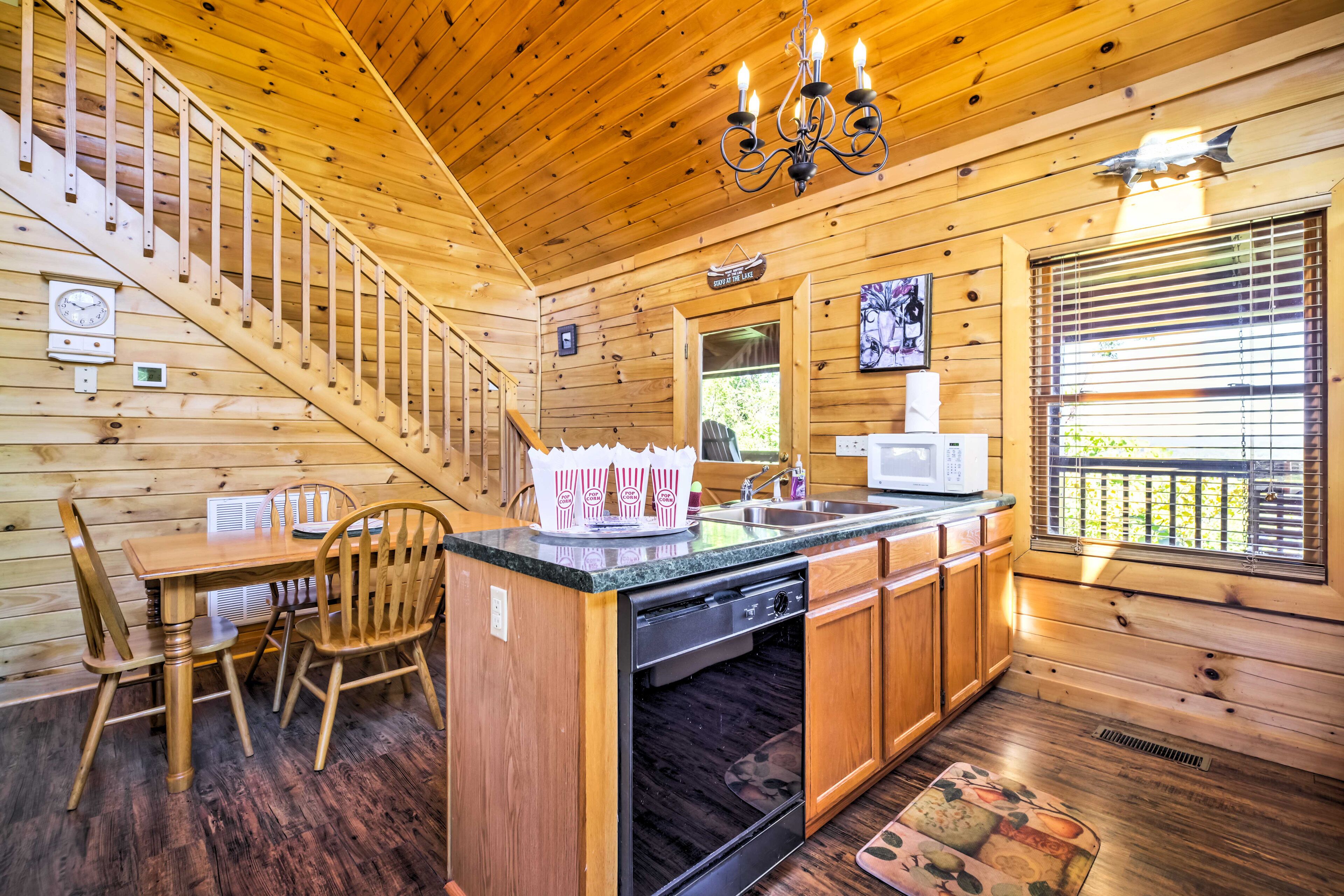 L’intérieur d’une cabane en bois comprend un coin repas, une cuisine et un escalier.