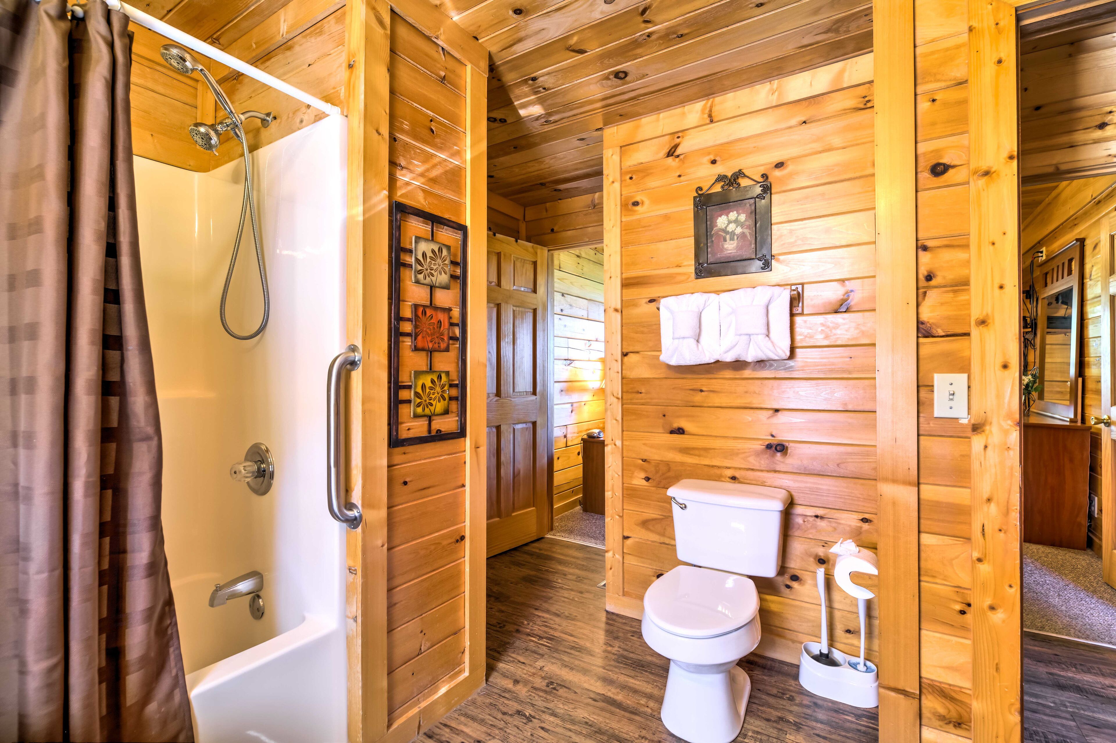 A wooden cabin bathroom with a shower, toilet, and a wooden door.