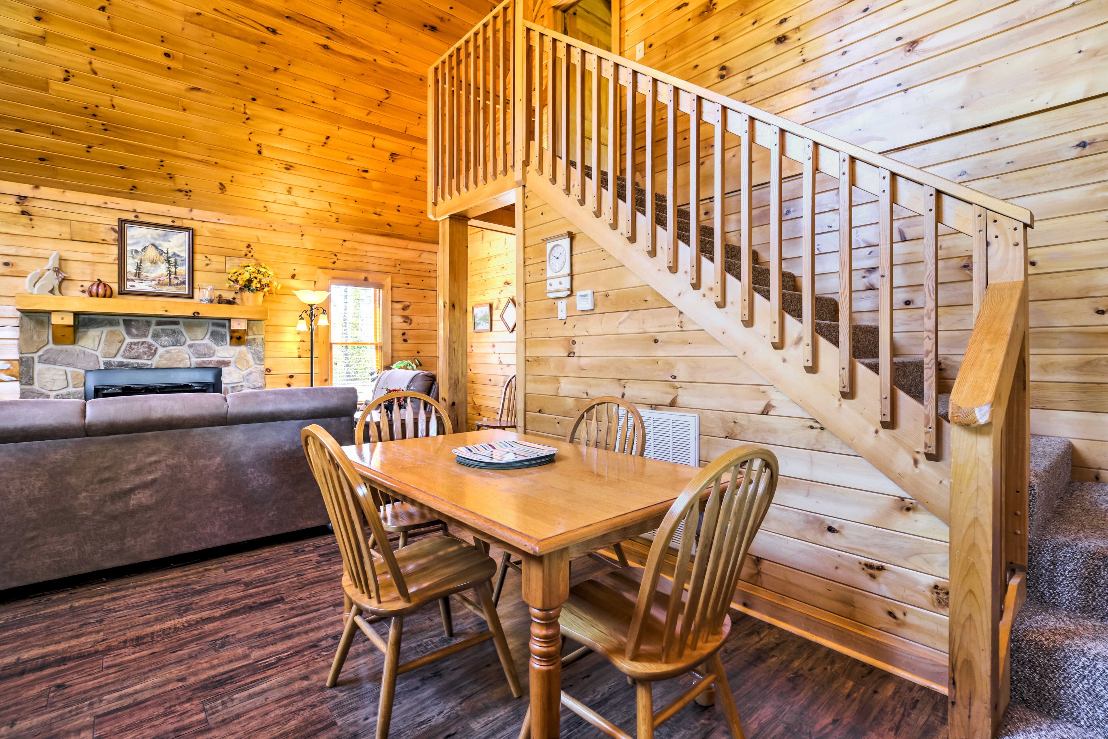 Un intérieur en bois comprenant une table à manger, des chaises, un canapé et un escalier.