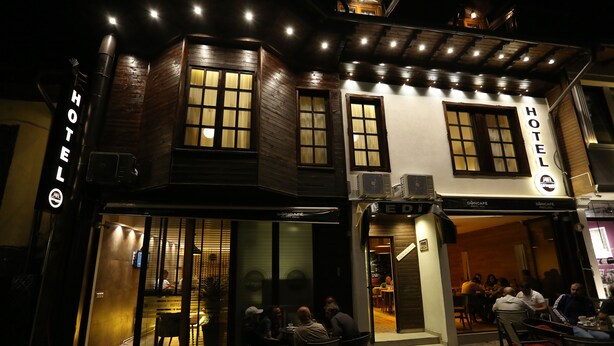 A hotel with a modern facade, large windows, and outdoor seating area. - Hotel Edi Imperial (Prizren)