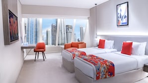 Quarto de hotel moderno com duas camas, uma escrivaninha e uma cadeira.