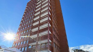 A tall, modern hotel with multiple balconies, a clear sky, and a snowy mountain backdrop. - Large apartment for 8 in Plagne Centre, balcony, pets allowed (La Plagne)
