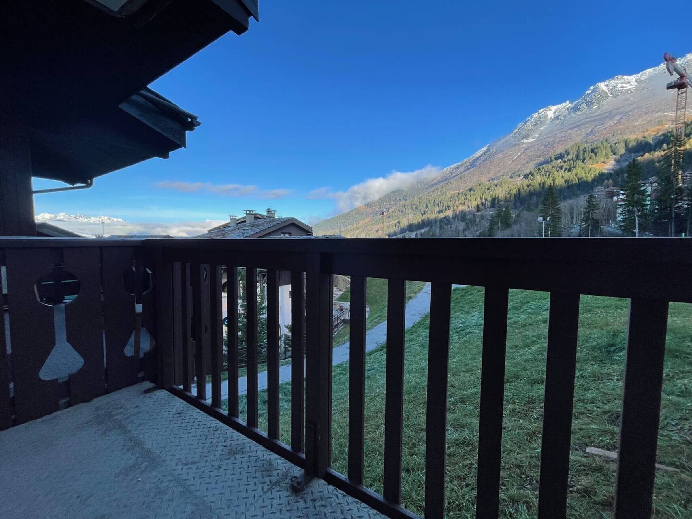 A balcony with a view of a mountain and a clear sky.
