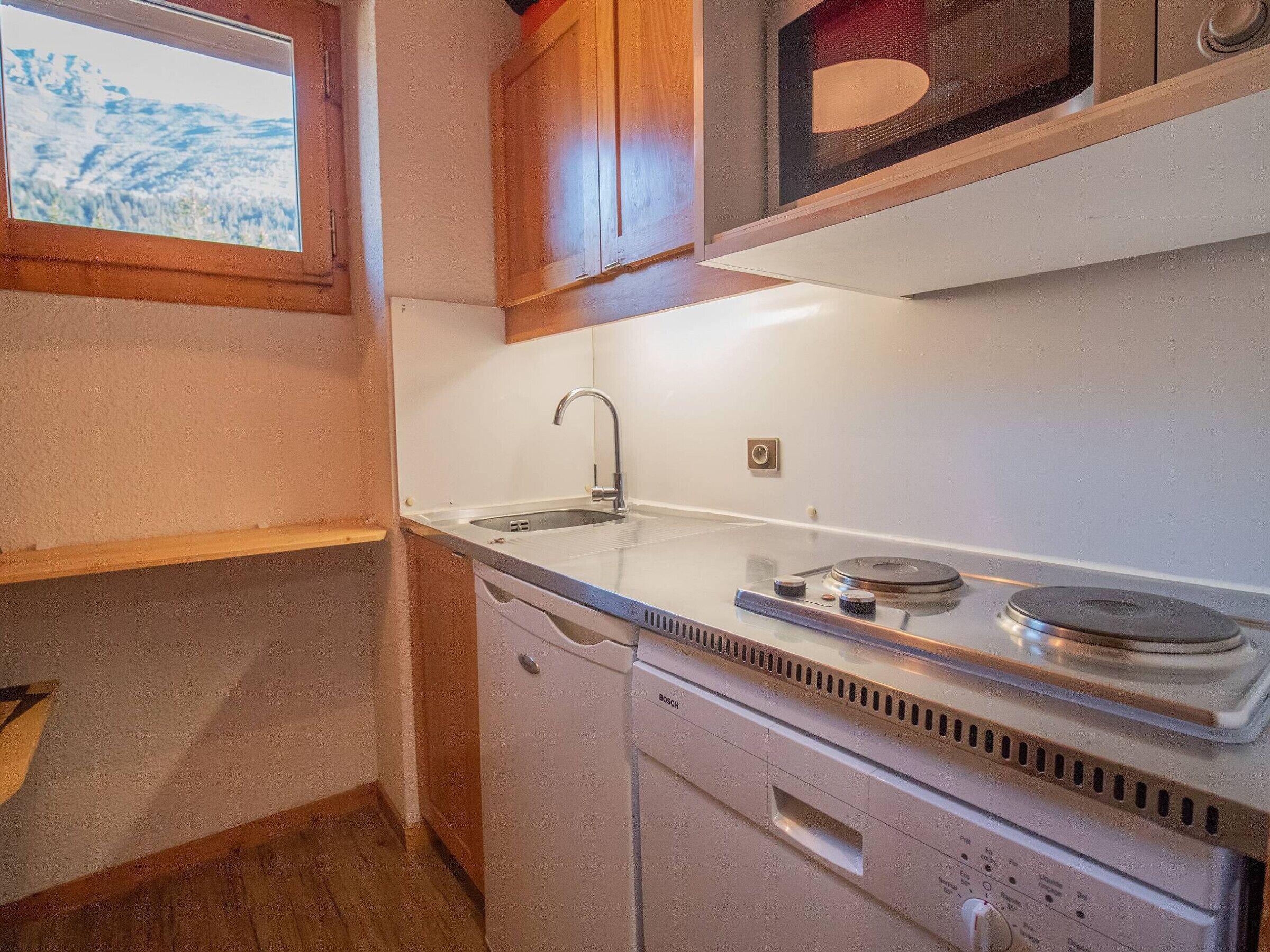 Cocina compacta con fregadero, estufa y microondas.
