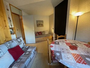 Um quarto aconchegante com uma cama, um sofá, uma mesa e uma luminária.