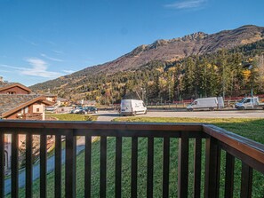 A mountain view with a parking area and buildings in the foreground.