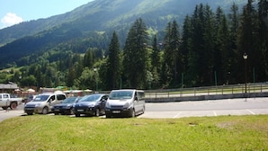 A parking area with cars and a mountain backdrop.