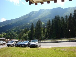 A parking area with cars and a mountain backdrop. - 1-bedroom in central Valmorel, close to shops and lifts (Valmorel)