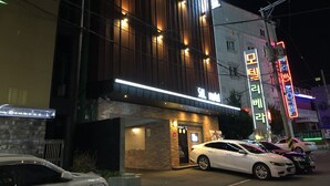 A modern building with illuminated signage and a brick entrance. - Sol Motel (Busan)