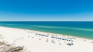 A beach with white sand, clear blue water, and a wooden walkway leading to the shore. - 4 Bedroom Gulf Front Phoenix Orange Beach 806 (Orange Beach)