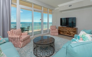 Relax in this stylish living room with a balcony offering ocean views, a flat-screen TV, and a comfortable seating area.