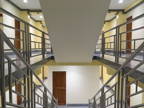 A multi-level interior with metal railings, a central door, and a staircase. - Baan Wanchart Bangkok Residences (Bangkok)