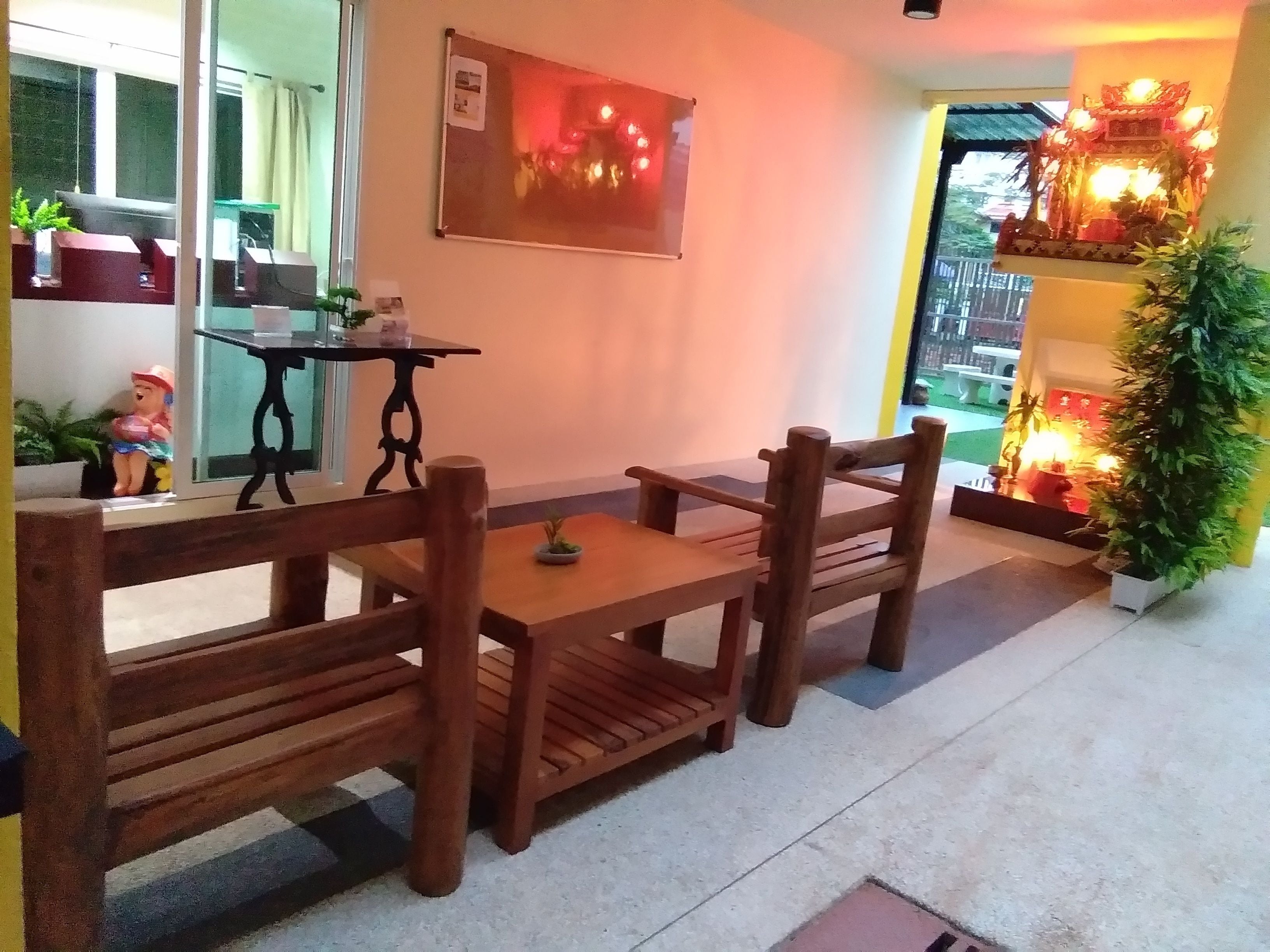 A wooden dining table with four chairs, a small table with a plant, and a decorative item on the wall.