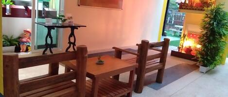 A wooden dining table with four chairs, a small table with a plant, and a decorative item on the wall.